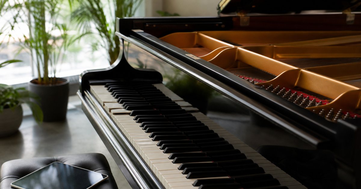 When should you consider a player system in a high-end acoustic grand piano?